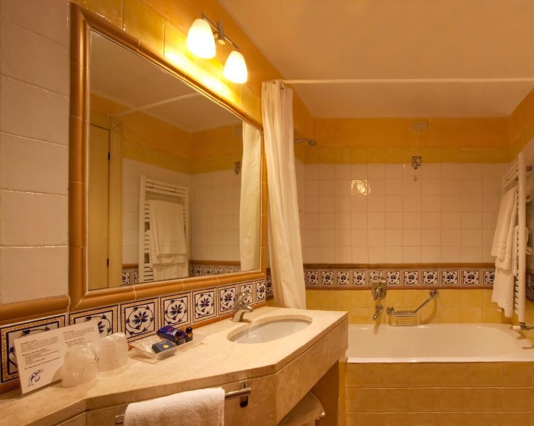 Une salle de bain avec un lavabo, un miroir et une baignoire.
