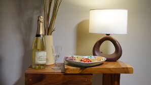 A wooden desk with a bottle of wine, a glass, and a plate of food. - Casa Vacacional con Vista al Chimborazo en Chambo (Chambo)