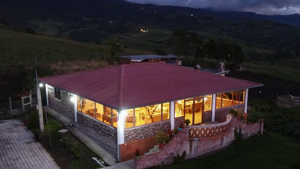 A house with a red roof, large windows, and a brick exterior. - Casa Vacacional con Vista al Chimborazo en Chambo (Chambo)