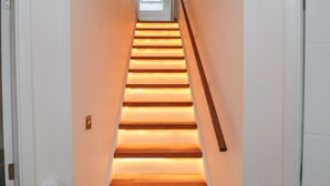 Un escalier avec des marches en bois et un éclairage intégré.