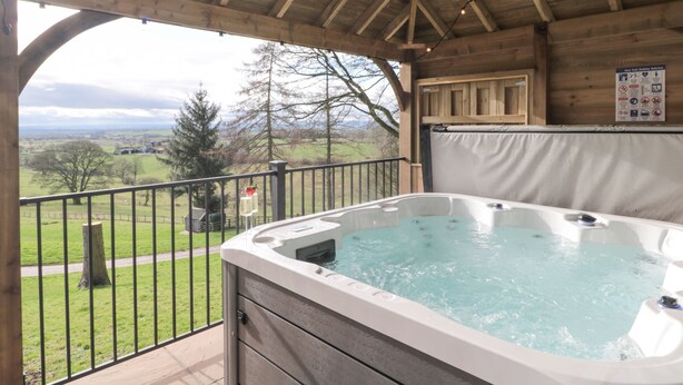 Un bain à remous dans un chalet en bois avec vue sur la campagne.