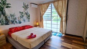 A bedroom with a bed, a nightstand, a wall mural, a window with curtains, and a wooden floor.