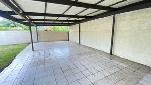 A covered patio area with tiled flooring and a concrete wall. - TAHITI - Taharuu Bungalow Surf Piti (Papara)