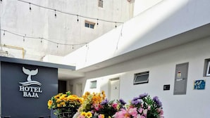 Un carrito con flores frente a un edificio que dice 'HOTEL BAJA'.