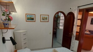 Una camera da letto con un letto, una cassettiera e uno specchio.
