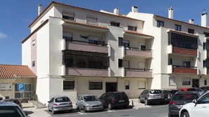 A multi-story residential building with a parking area in front. - Global Guest Sintra (Sintra)