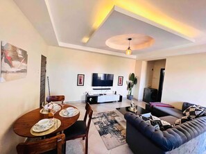 Enjoy meals together at the central dining area with a table for four, accompanied by a sofa and coffee table.