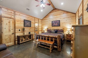 Cozy bedroom with a bed, bedside tables, and a bench, set amidst rustic charm.