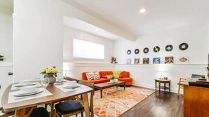 A modern living room with a dining area, a sofa set, a coffee table, and a wall decorated with vinyl records. - Retro Vibes - King Bed - Long Stays - Garage - Wi-Fi!
 (Edmonton)