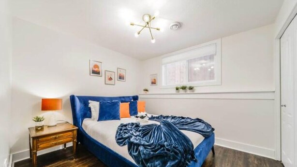 Un dormitorio con cama, mesita de noche y ventana.