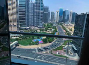 Experience the vibrant cityscape from a high vantage point, with a mix of architectural styles and a well-maintained green space nearby.