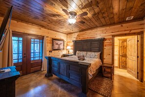 Cozy bedroom with a dark wooden bed frame, ceiling fan, and a framed picture on the wall.