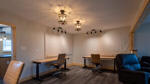 Una sala de conferencias con una mesa de madera, dos sillas y una butaca azul.