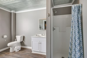 Un baño con inodoro, lavamanos y cortina de ducha.