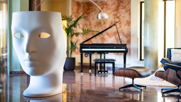 Un intérieur moderne agrémenté d’un piano, d’une sculpture blanche et de meubles contemporains.