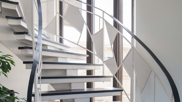 A spiral staircase with white railings and black steps. - Appart hôtel Chanzy Angoulême Soyaux (Soyaux)