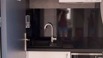 Una cocina compacta equipada con fregadero, microondas y refrigerador.