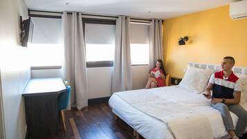 A bedroom with a bed, a desk, and a chair.