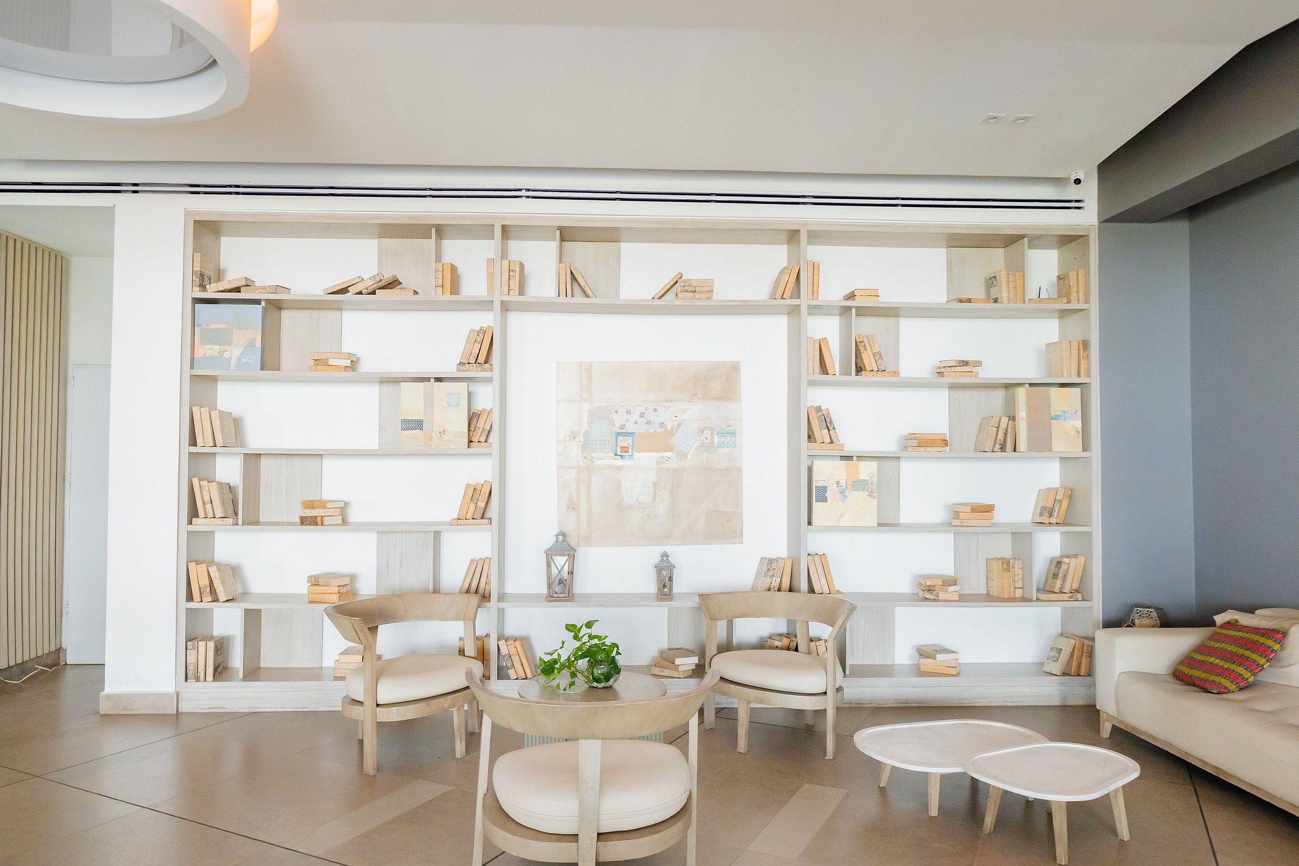 A modern living room with a built-in bookshelf, a round table with chairs, and a sofa.