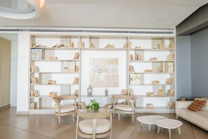 Un salon moderne avec une bibliothèque intégrée, une table ronde entourée de chaises et un canapé.