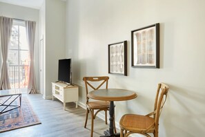 Relax in this stylish living room with a large window, flat-screen TV, and comfortable seating area.