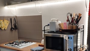Une cuisine compacte équipée d’un four à micro-ondes, d’une cuisinière à gaz et d’un lave-vaisselle.