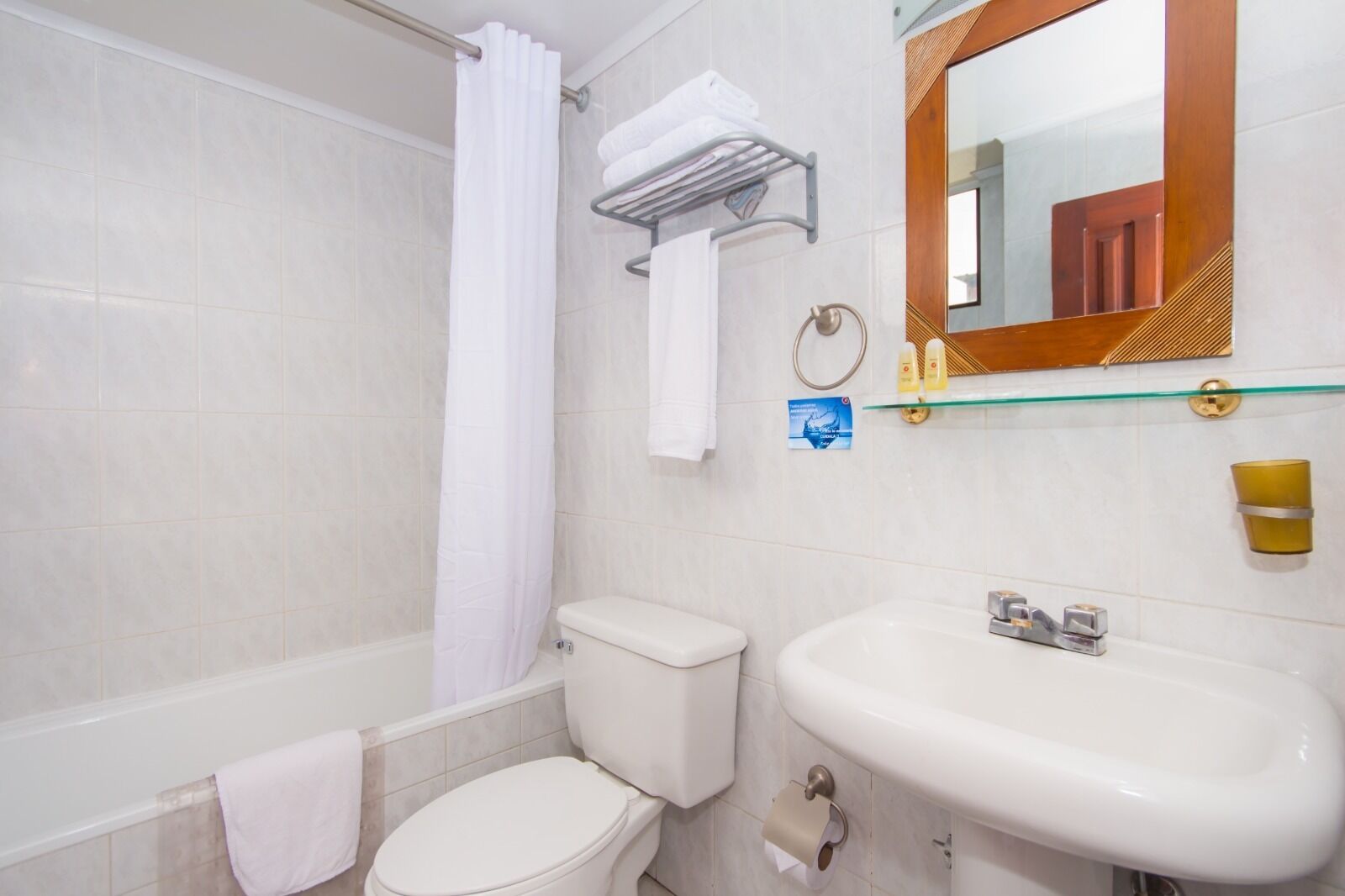 Un baño con inodoro, lavamanos y zona de ducha.