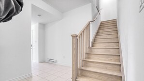 A staircase with wooden steps and a handrail, leading to an upper floor.