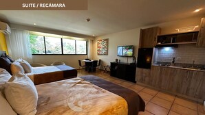 A suite with a bed, a desk, a TV, and a kitchenette. - Beach and Golf Escape in your private Luxury Resort Studio in Coronado (Playa Coronado)