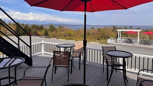 A deck with outdoor seating, a view of a lake, and a gazebo. - Acadia Ocean View Hotel (Bar Harbor)