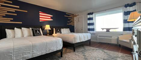 Une chambre d’hôtel avec deux lits, un tapis à motifs, un luminaire au plafond, une fenêtre avec des rideaux et une cuisinière.