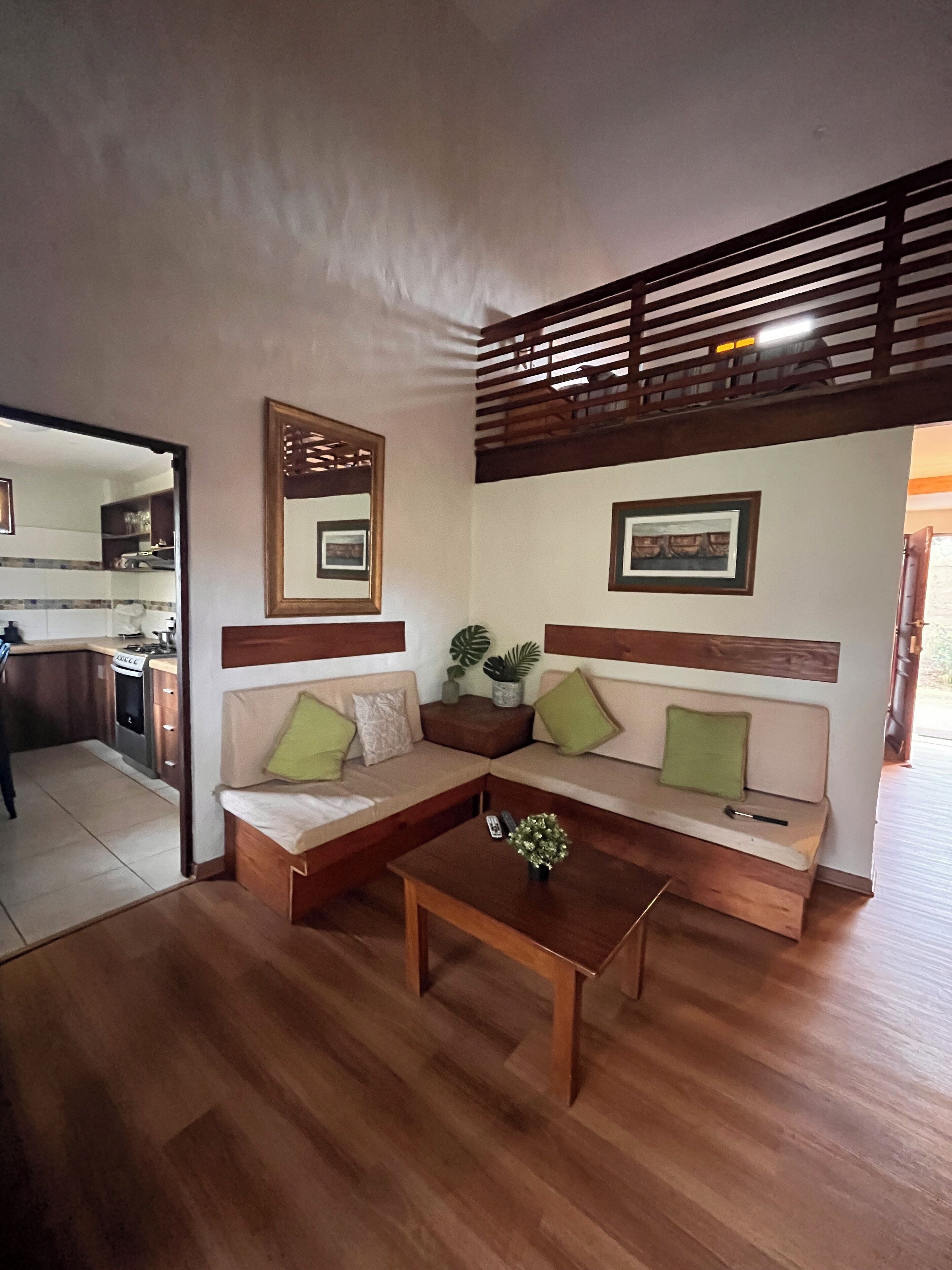 Sala con DirecTV e ingreso a la cocina