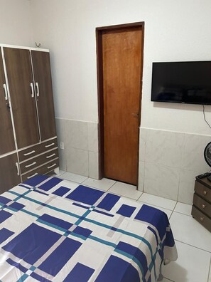 A bedroom with a bed, a wardrobe, a television, and a fan. - Grand Maracanaú (Maracanau)