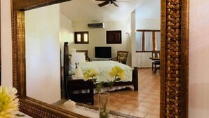 A bedroom with a bed, a television, and a ceiling fan. - Rancho Utairs
 (La Romana)