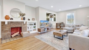 Una sala de estar moderna con chimenea, televisor y una zona de estar acogedora.