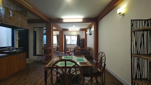 Un comedor con una mesa, sillas y un televisor sobre un mueble.