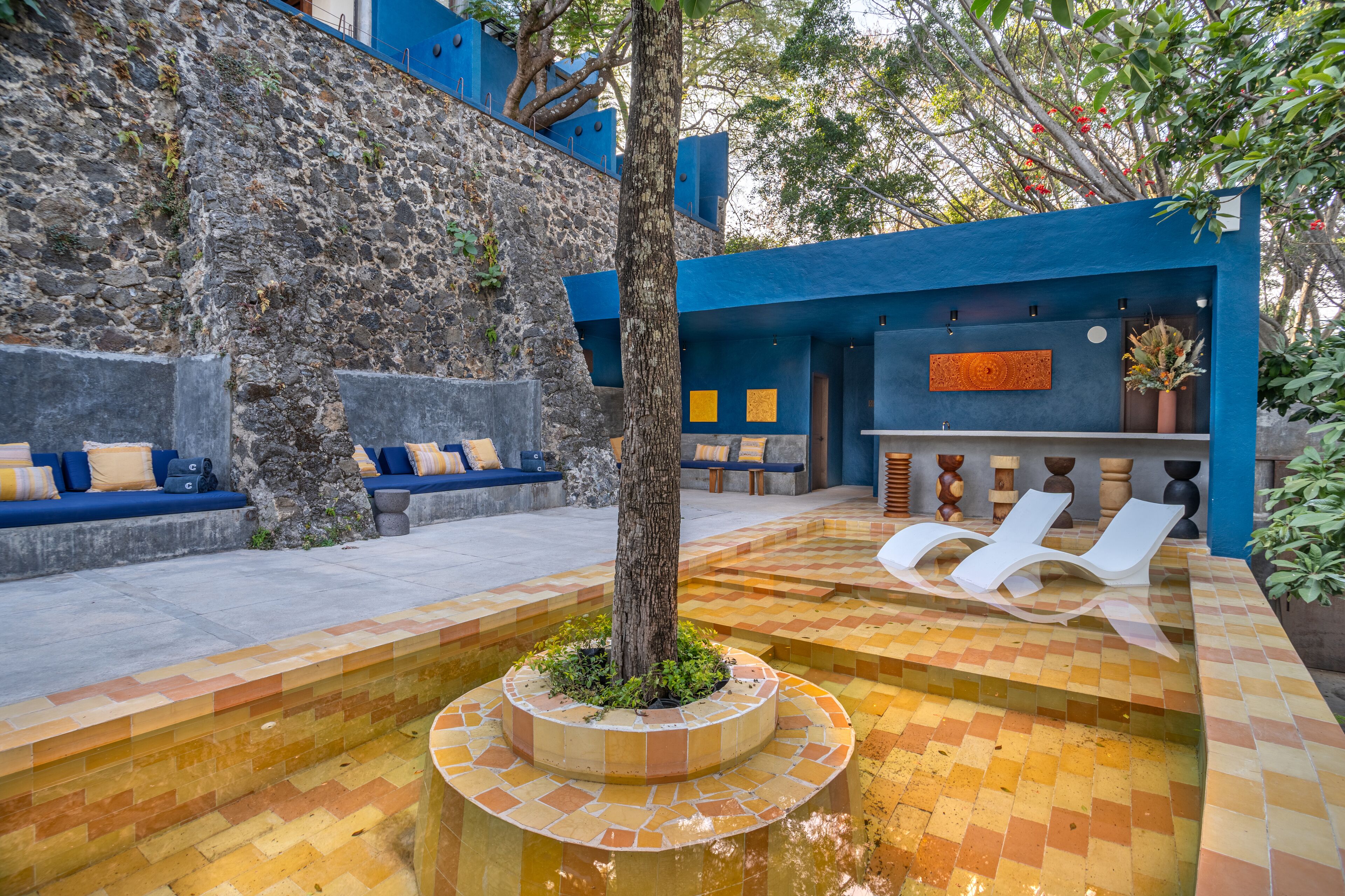 Una piscina al aire libre, sombrillas, sillones reclinables de piscina