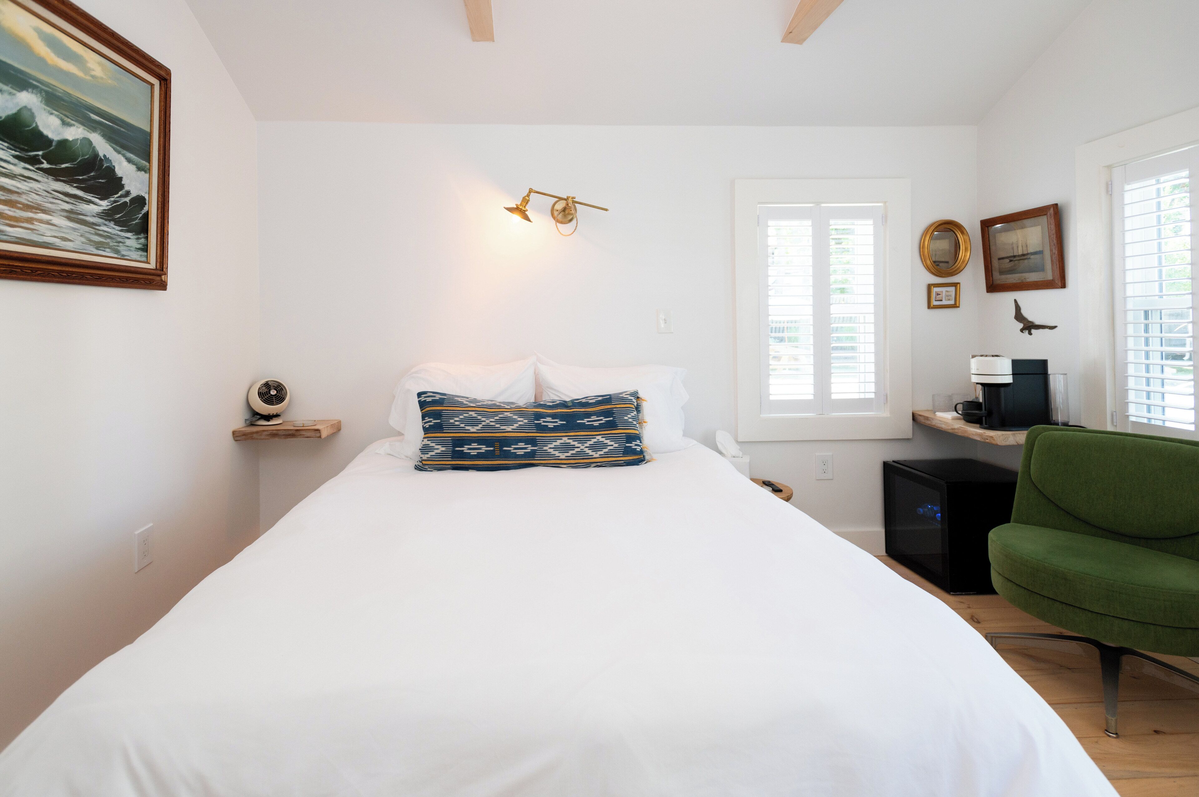 A bedroom with a bed, a desk, a chair, and a window.