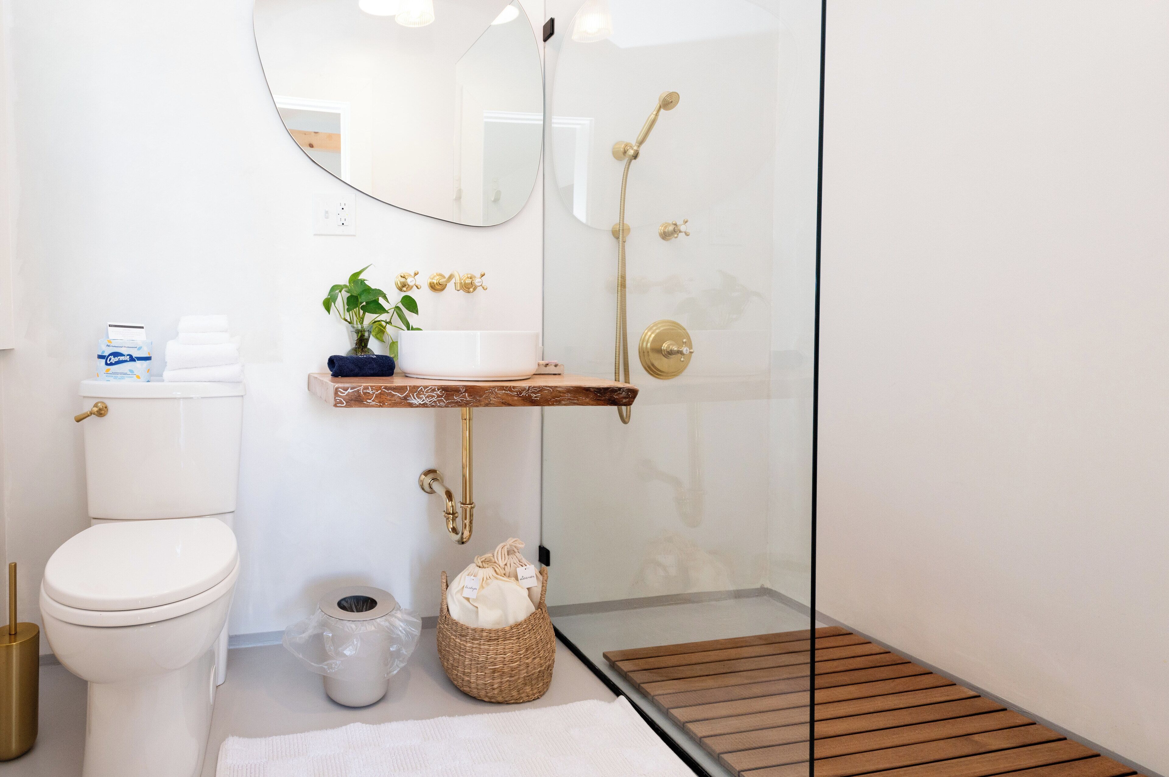 A modern bathroom with a toilet, sink, and shower.