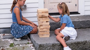 Two children playing with wooden blocks outside a house with a door and a window. - sisu, a boutique motel (Plymouth)