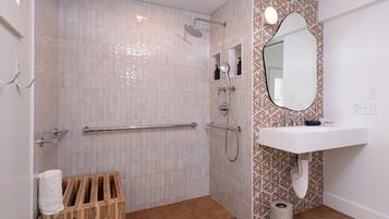 Un baño moderno con ducha, inodoro y lavamanos.