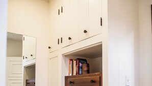 A hallway with a wooden dresser, white cabinets, and a mirror. - Suite 103 also known as the Arkansas Suite (Cherokee Village)