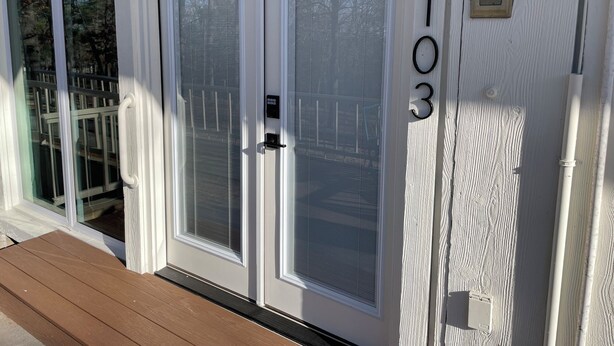 A white door with frosted glass panels, a number '103' on the wall, and a small mailbox. - Suite 103 also known as the Arkansas Suite (Cherokee Village)