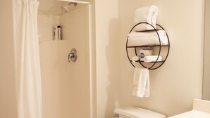 A bathroom with a shower, toilet, and sink.