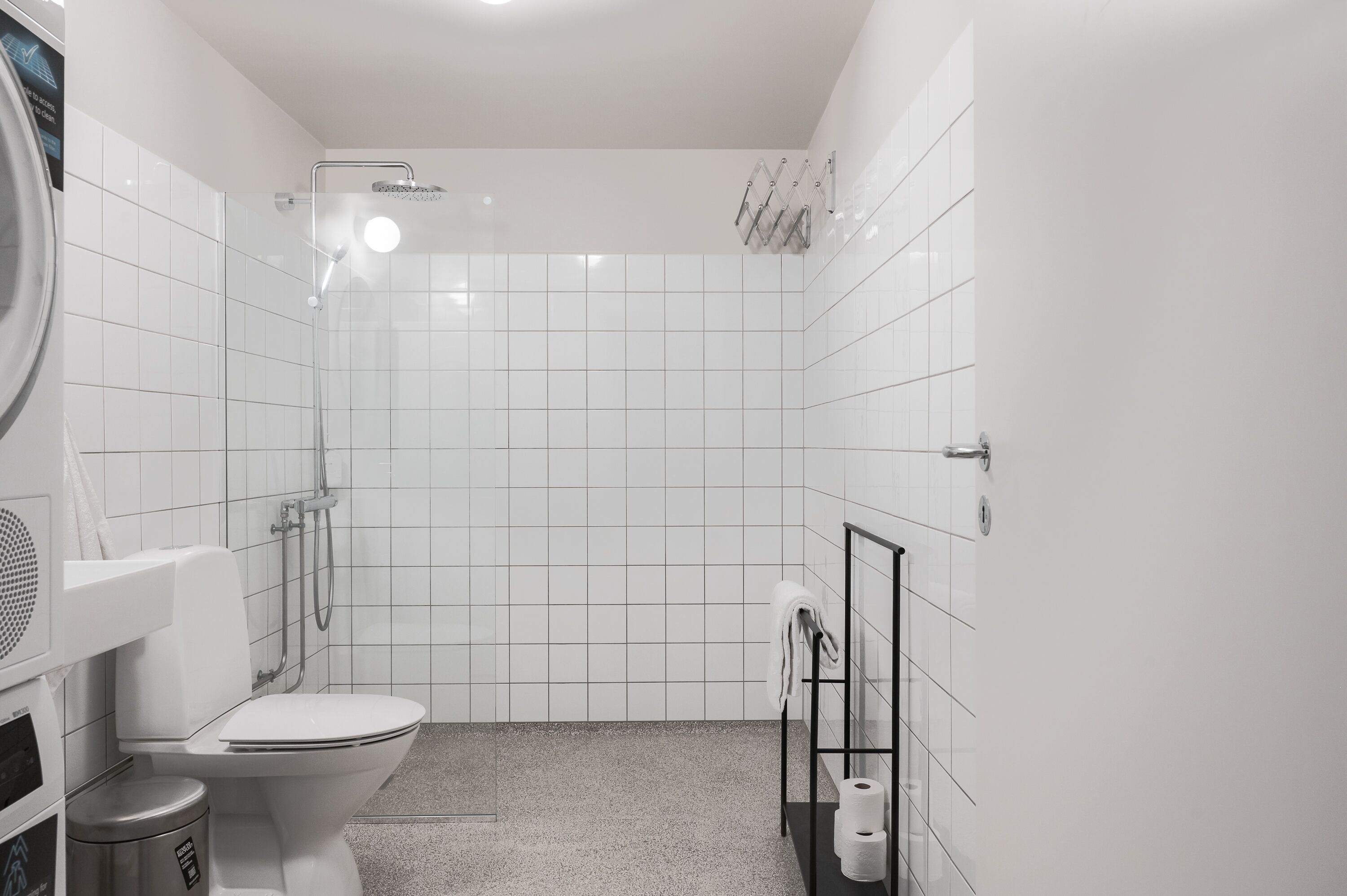 Un baño moderno con inodoro, ducha y toallero.