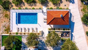 An aerial view of a property with a swimming pool, sun loungers, and a covered patio area. - Villa Olivella with Heated Pool (Vodice)