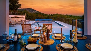 A dining table set for six with a view of a pool and sunset. - Villa Olivella with Heated Pool (Vodice)