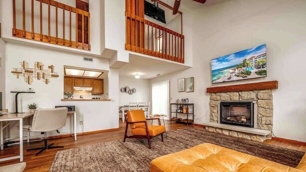 A spacious living area with a fireplace, a dining area, and a kitchen. - Family-Friendly 2BR Condo w/ Private Garage - Minutes from Zoo & Downtown (Fort Wayne)