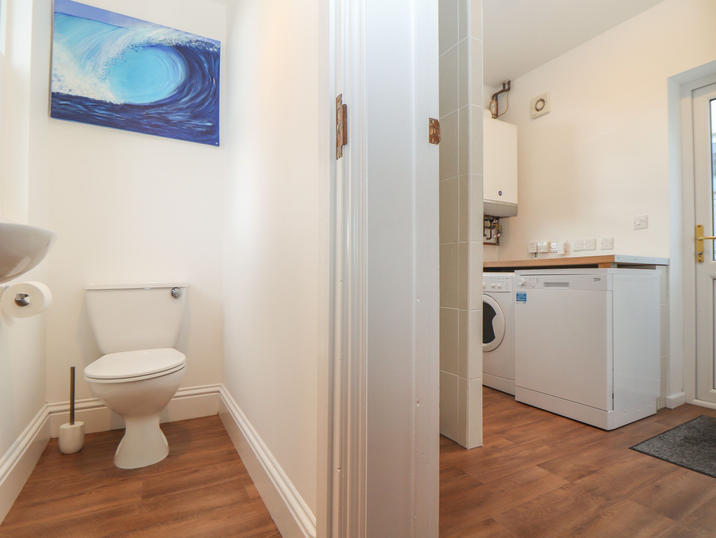 A bathroom with a toilet, a sink, and a washing machine.