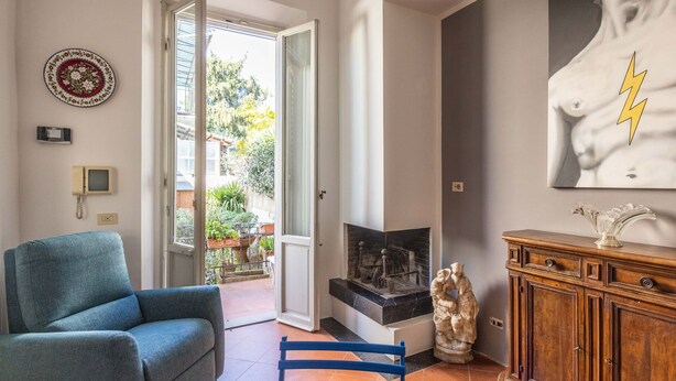 Ein Wohnzimmer mit einer Couch, einem Tisch, einem Kamin, einer Statue und einem Gemälde.